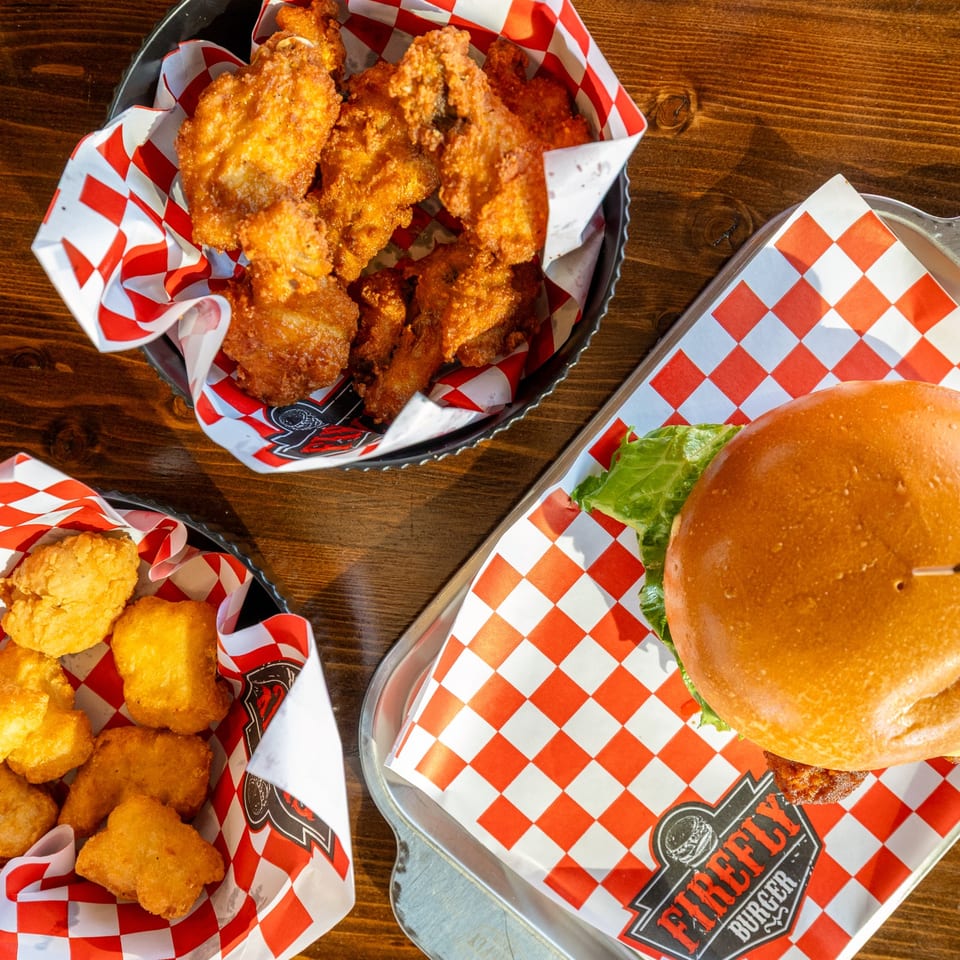 Burger with wings and nuggets on trays